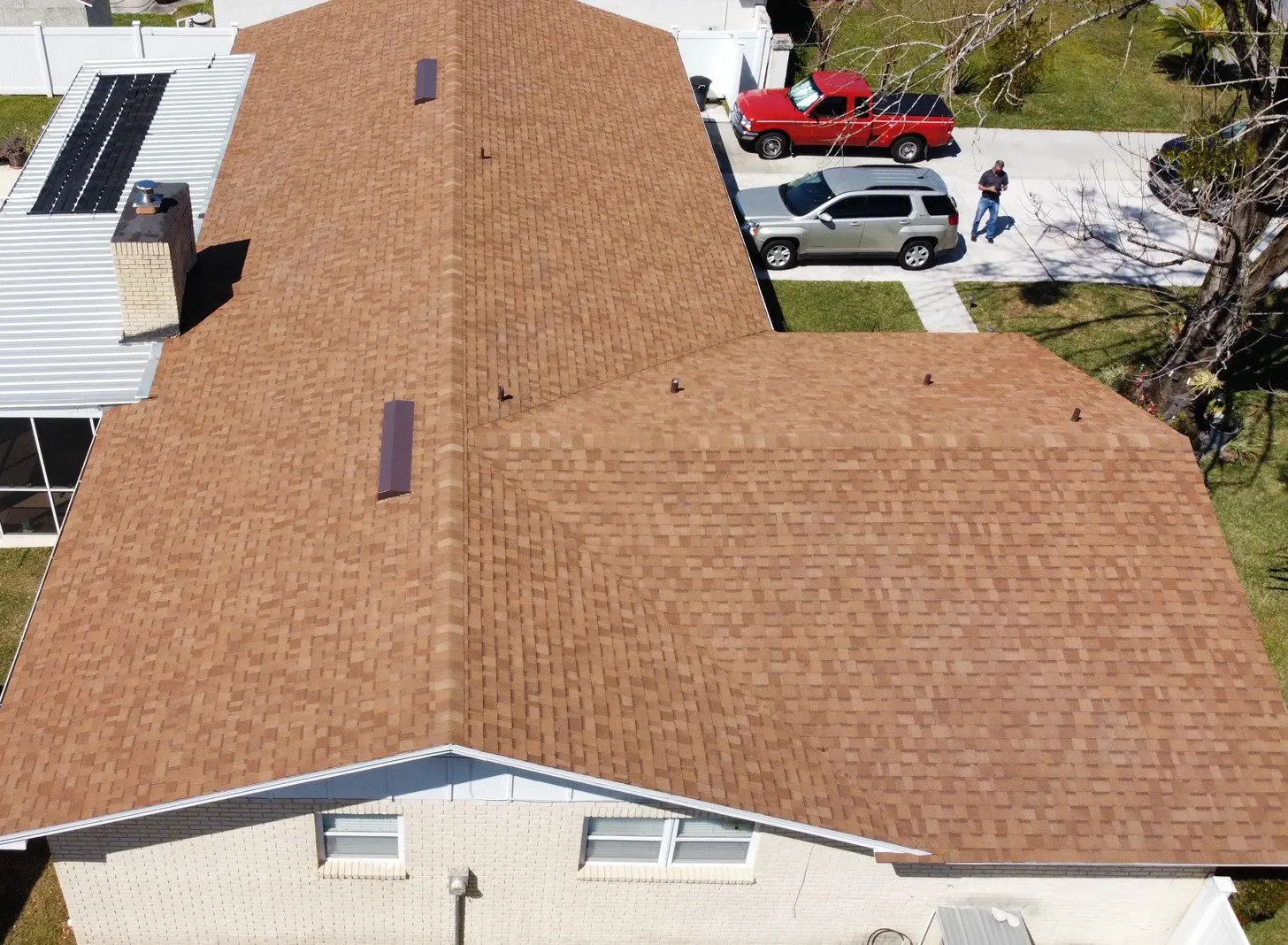 Aerial view of house with brown roof.