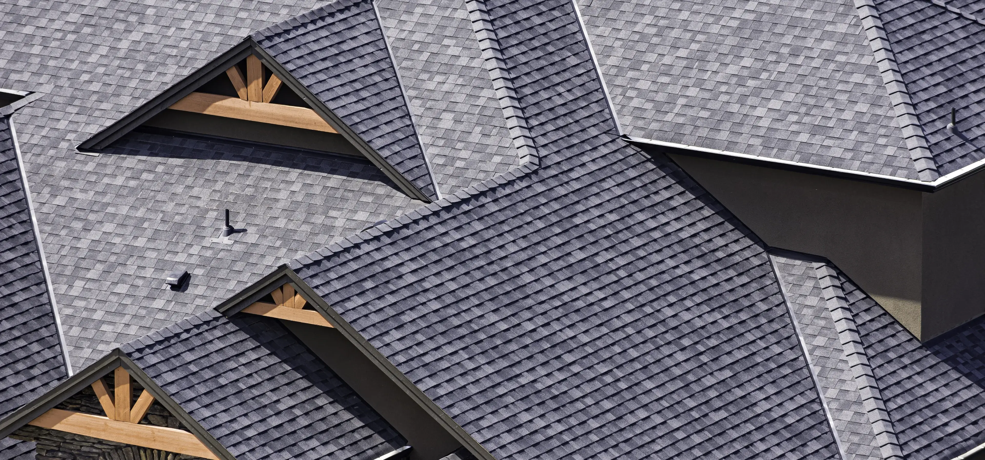 Complex roof with gray shingles and gables.
